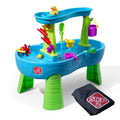 Kids water table with colorful toys, accessories, and folded black cover on a white background