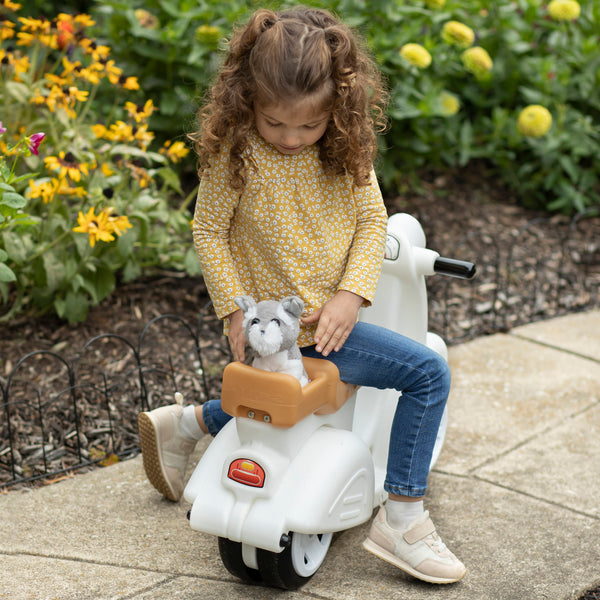 Ride Along Scooter™ - White with child placing toy in back storage
