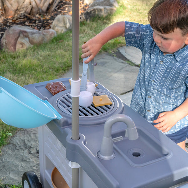 Grill & Go BBQ Cart with Lights and Sounds™ boy pretending to cook on grill