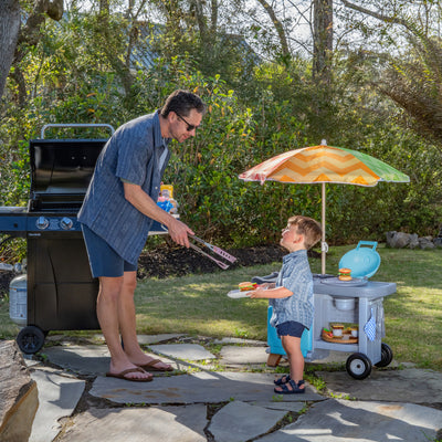 Grill & Go BBQ Cart with Lights and Sounds™ pretending to cook along side Dad.