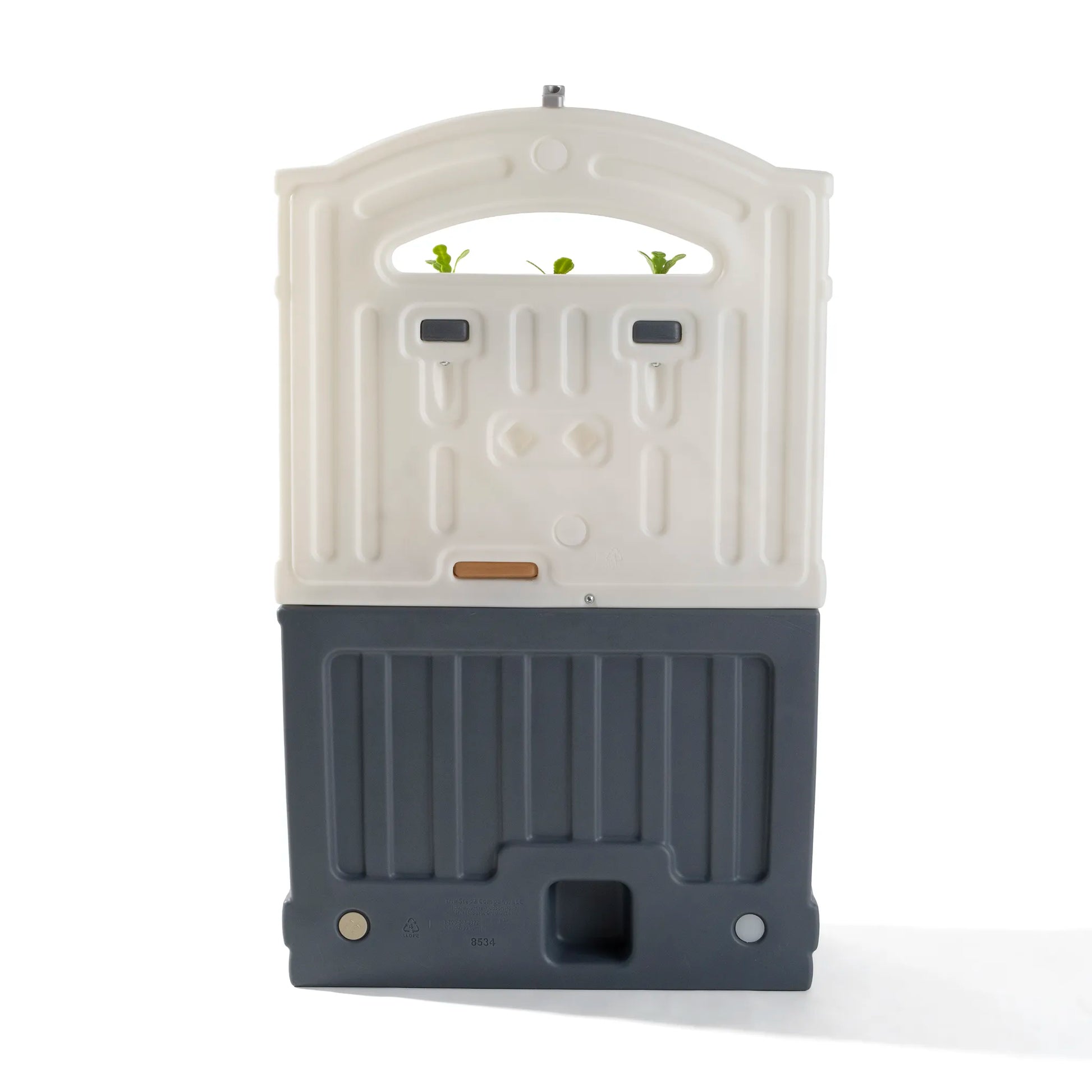 Back view of Garden Fresh Kitchen™ on white background — white arched backsplash panel with rectangular slots, dark gray base unit with ridged texture, tan countertop accent strip, and drain hole in base