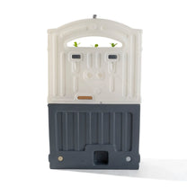 Back view of Garden Fresh Kitchen™ on white background — white arched backsplash panel with rectangular slots, dark gray base unit with ridged texture, tan countertop accent strip, and drain hole in base