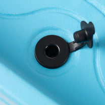 Close-up of the Tropical Splash Water Park™ drain plug on the bottom of the blue basin — black circular plug against blue plastic surface