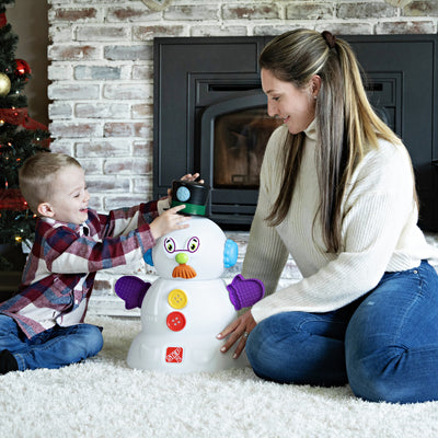 My First Snowman™ with child placing hat on snowman
