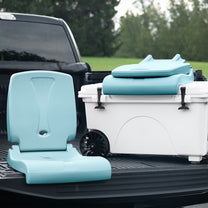Flip Seat™ in teal shown open in truck bed beside a large white cooler with another folded Flip Seat™ resting on top