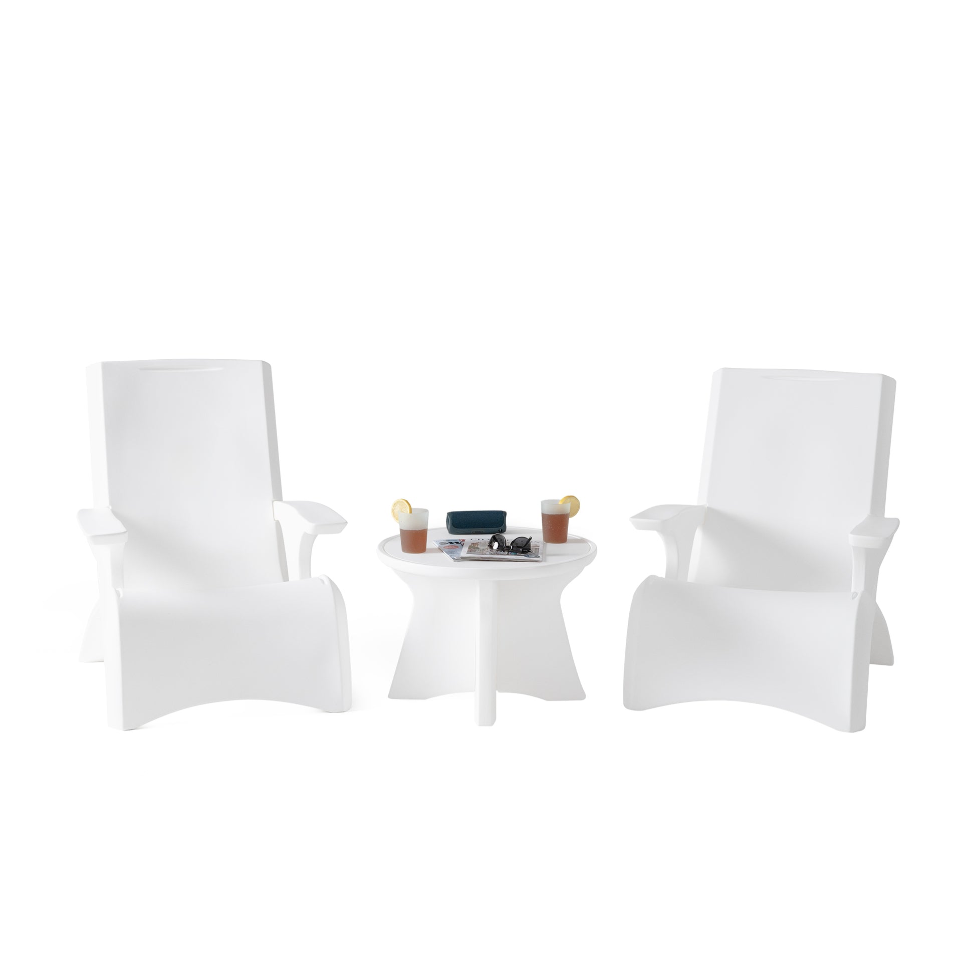 Vero In Pool Accent Table™ flanked by two white Vero Adirondack chairs on white background — drinks, sunglasses, and magazine on tabletop; full Vero Collection styling scene
