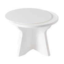 Vero In Pool Accent Table™ side-angled product view on white background — shows round top with raised lip, curved center column, and four-panel star/X-shaped base; smooth white matte finish