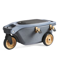 Step2 EverTough Garden Hopper — gray hopper on two amber front wheels and one rear caster, black rubber seat pad, with gold tool hooks, on white background