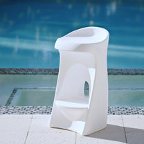 Step2 Vero In-Pool Stool in white — tall sculptural bar-height pool stool with curved contoured seat and oval cutout in the base column; standing on stone pool deck with pool behind