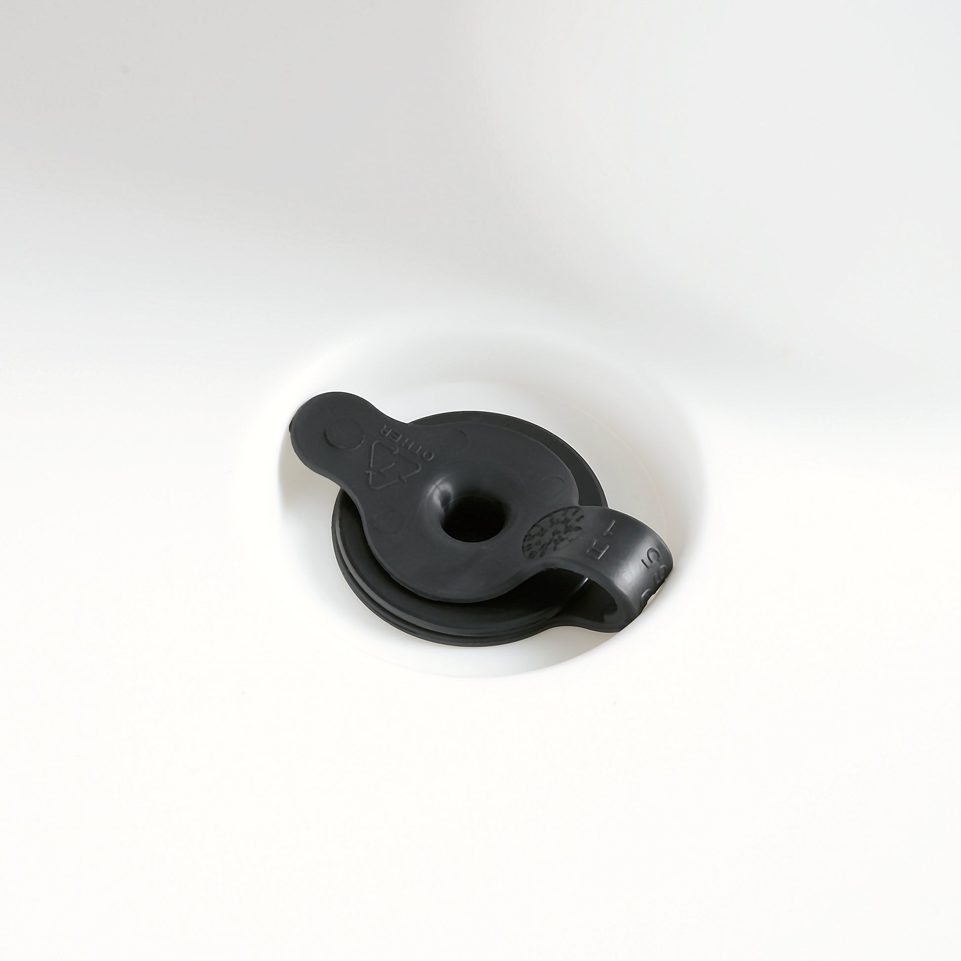 Close-up of black drain plug in white Sunshine Springs Splash Table basin