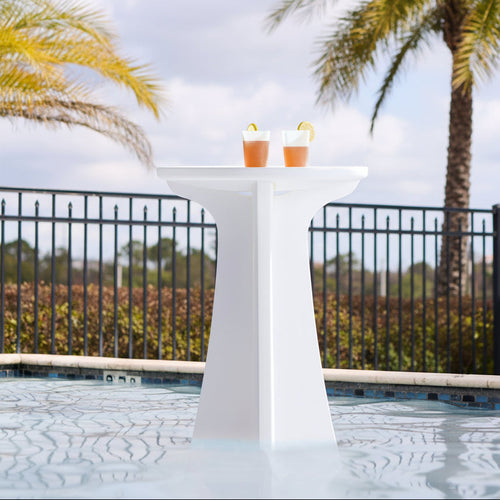 Step2 Vero In Pool High-Top Bistro Table — white pedestal table with two cocktails in pool, with palm trees and iron fence