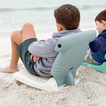 Step2 Kids Hammerhead Flip Seat — two boys on beach, older boy on gray hammerhead seat and younger boy on teal seashell seat, both looking at ocean