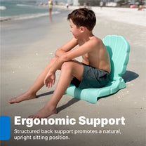 Kids Seashell Flip Seat in teal — boy in board shorts sitting on seashell seat on beach facing ocean