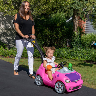 Whisper Ride II™ - Pink with child being pushed in car