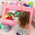 2-in-1 Toy Box & Art Lid™ girl placing toys inside toy box