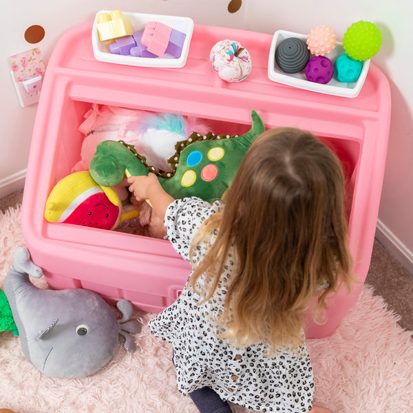 2-in-1 Toy Box & Art Lid™ girl placing toys inside toy box