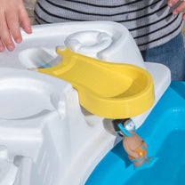 Close-up of yellow pouring chute accessory with toy figure sailing through into water basin of Fiesta Cruise Water Table