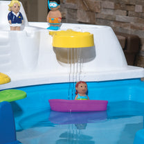 Close-up of Fiesta Cruise Water Table water section with yellow rain shower, purple toy boat with girl figure, and captain and diver figures on cabin deck