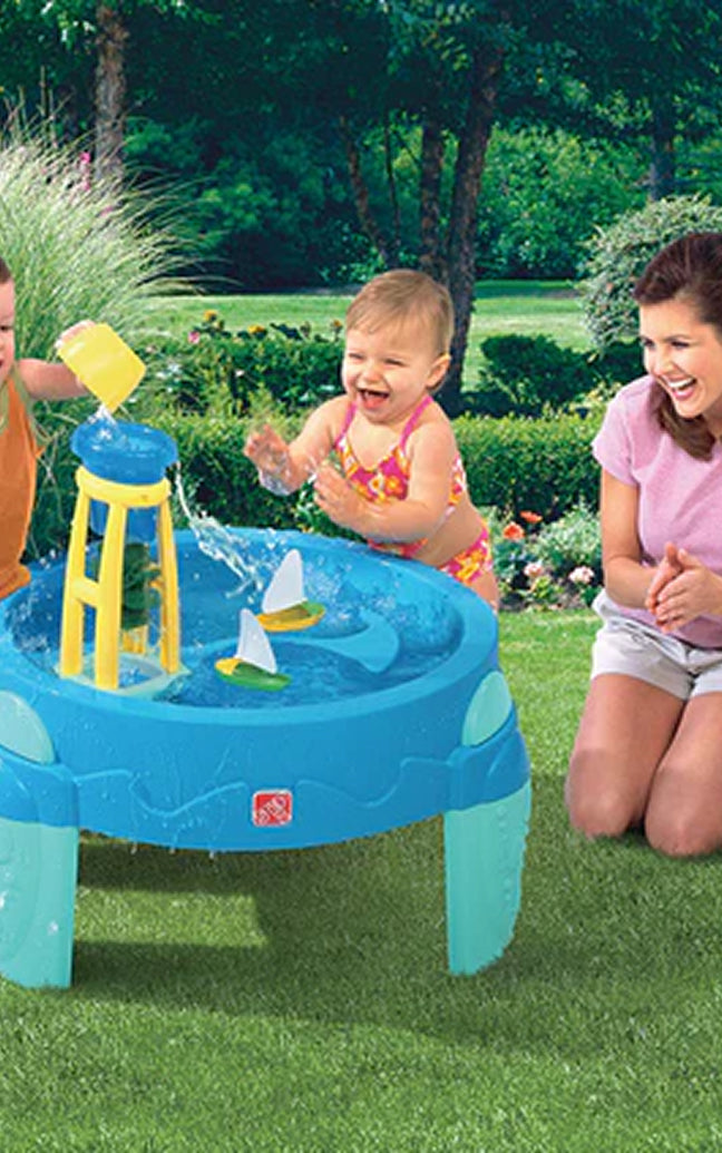 Children playing with a water table in a garden